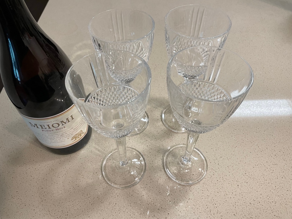 Picture of crystal wine glasses and a bottle of pinot noir wine.